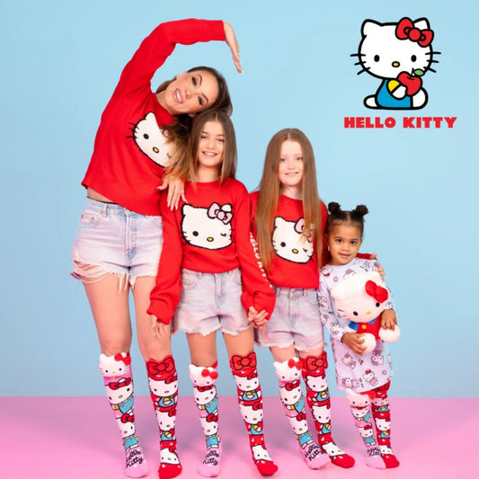 Chaussettes hautes Hello Kitty MADMIA dépareillées pour enfants, avec éléments en peluche 3D, une rose avec tête Hello Kitty, l’autre rouge avec pomme et nœud.