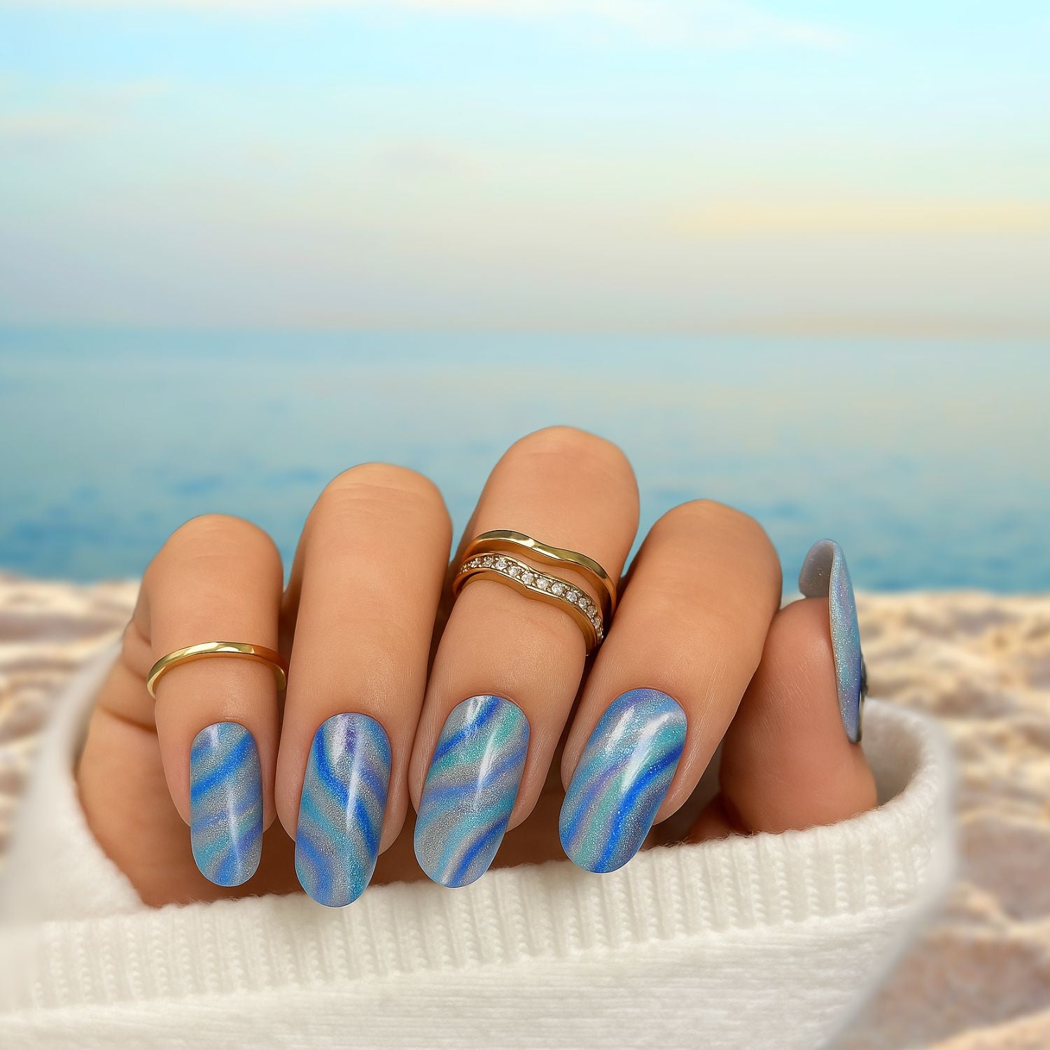 Manucure marbrée aux reflets bleus, turquoise et argentés, réalisée avec des stickers gel semi-permanent Emano – effet nacré lumineux et tendance.